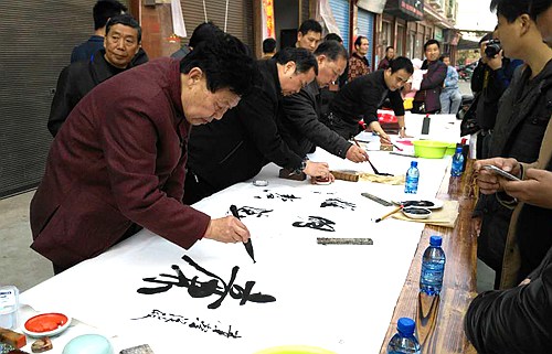书法家在新化县西河镇书写廉政作品赠相亲.jpg